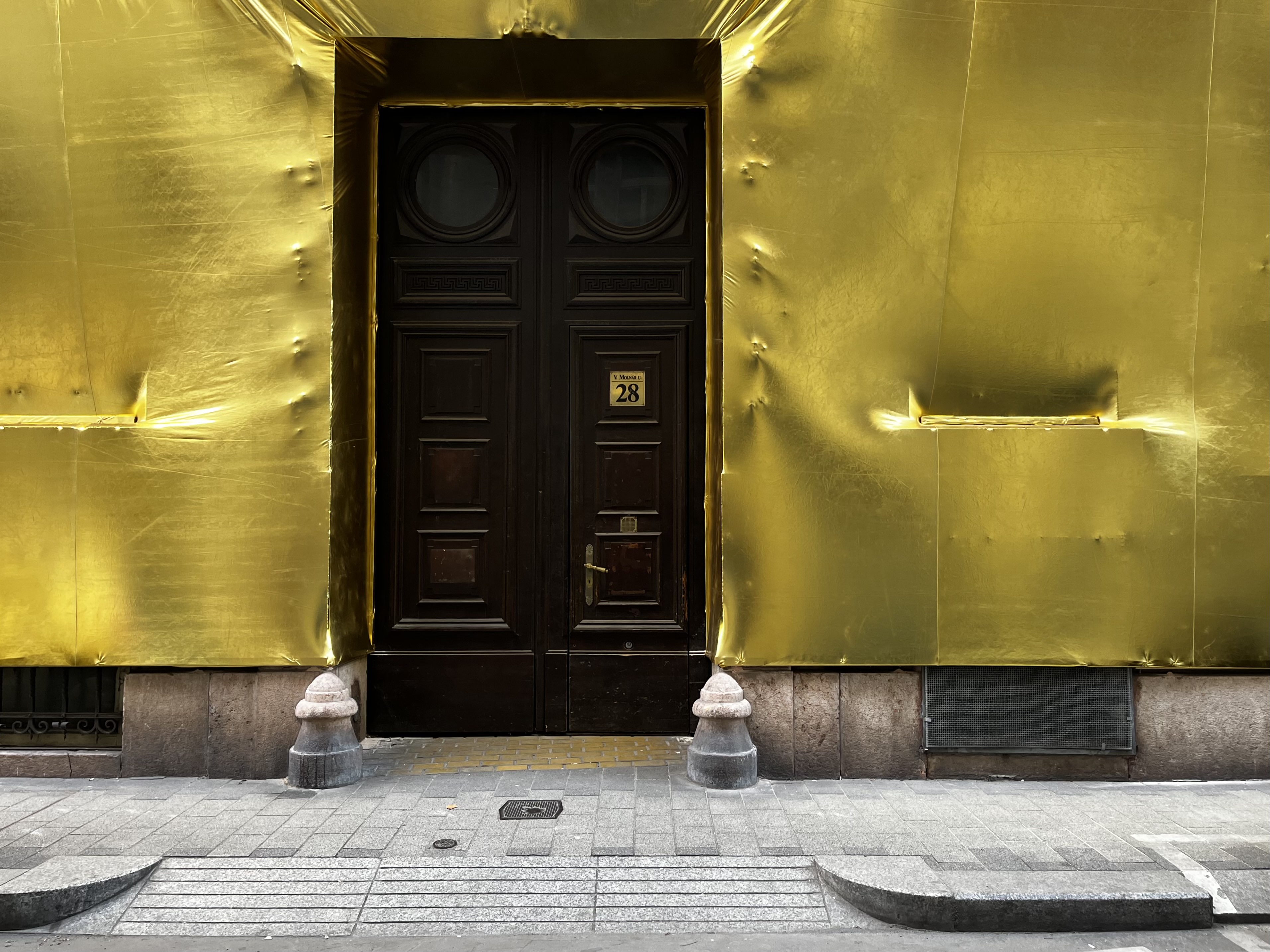 Miért vontak be aranyszínű textillel rossz állapotú palotákat Budapest belvárosában?